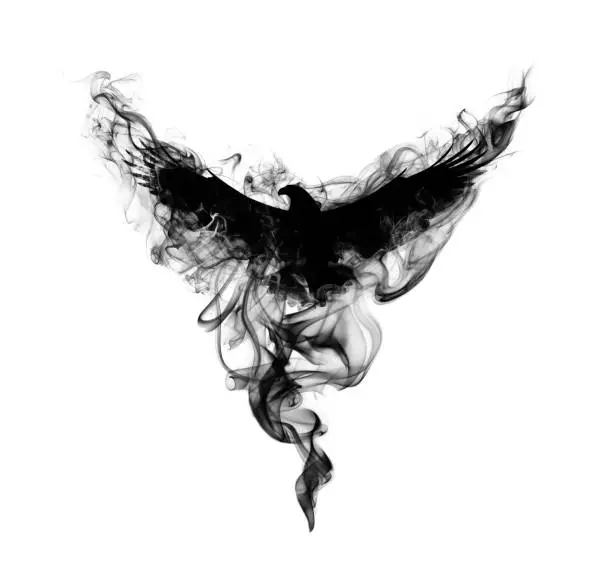 Photo of Silhouette of a flying eagle with spread wings in beautiful puffs of black smoke isolated on a white background. Silhouette of a flying eagle in clouds of smoke.