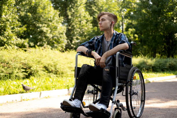istock young disabled man in wheelchair walking park 1427092940