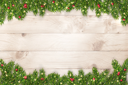 Christmas and New Year background with fir branches, glitter, christmas ornaments and lights on rustic wooden planks