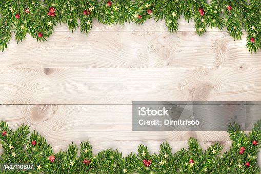 istock Christmas and New Year background with fir branches, glitter, christmas ornaments and lights on rustic wooden planks 1427110807