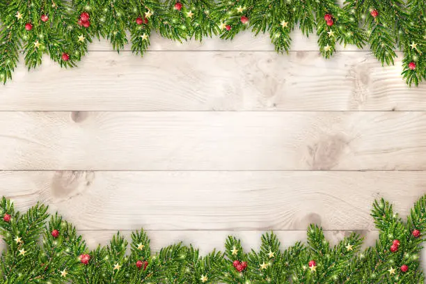 Vector illustration of Christmas and New Year background with fir branches, glitter, christmas ornaments and lights on rustic wooden planks