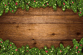 istock Christmas and New Year background with fir branches, glitter, christmas ornaments and lights on rustic wooden planks 1427111134