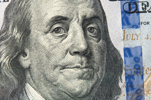Benjamin Franklin's face on the US 100 dollar bill. Closeup of Ben Franklin on a one hundred dollar bill. Benjamin Franklin portrait from hundred dollar bill, macro
