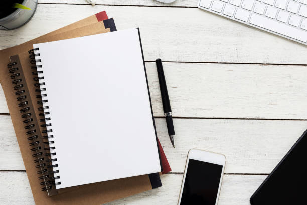 istock Top view, empty notebook and office supplies on the desk. 1427116391