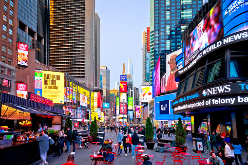 New York, USA - March 23 2022: New York City Times Square lights and architecture street view at dusk. One of the bussiest places in New York, visited by many tourists.