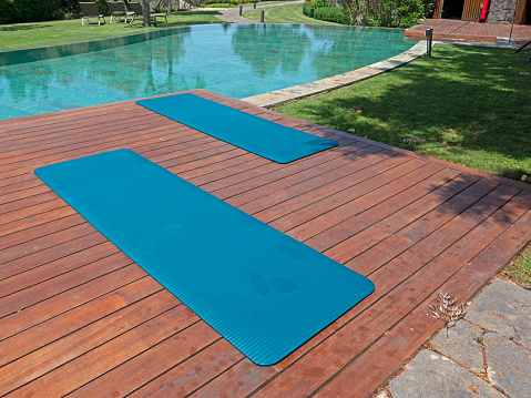 Yoga mat in the garden and pool