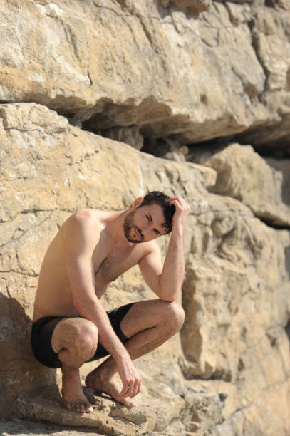 Young sexy man portrait near the rocks