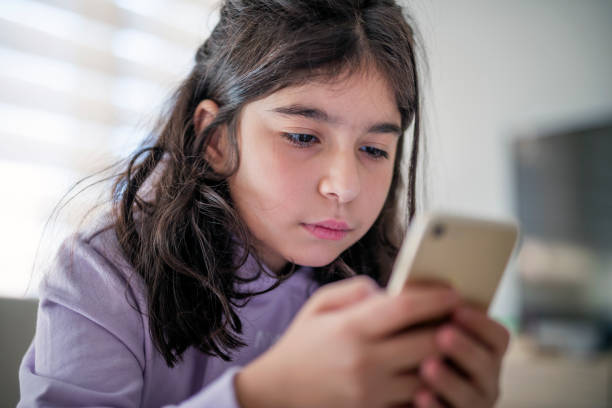 istock Little girl using smartphone at home 1427127239