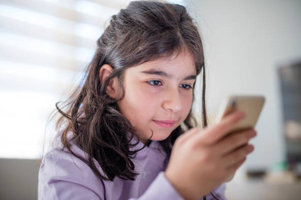 istock Little girl using smartphone at home 1427127244