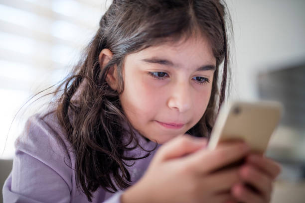 istock Little girl using smartphone at home 1427127245