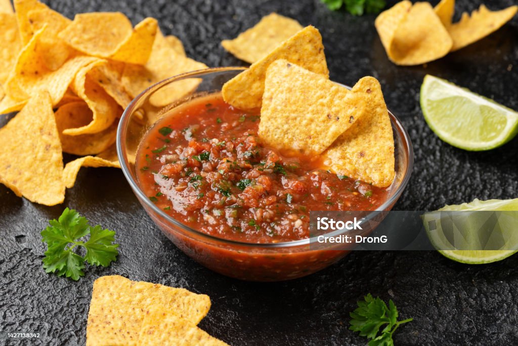 Mexican Tomato Salsa with lime, onion, jalapeno pepper, parsley and tortilla chips Mexican Tomato Salsa with lime, onion, jalapeno pepper, parsley and tortilla chips. Salsa Sauce Stock Photo