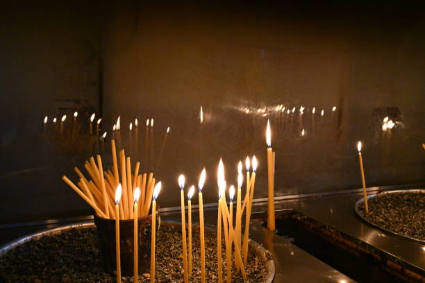 Thin long candles burning in a church.
