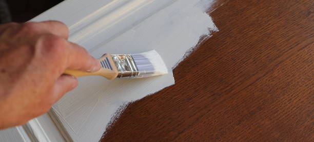 paint a brown cabinet with white paint - brushing human hand paintbrush artist imagens e fotografias de stock