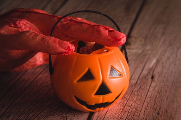 istock Halloween pumpkin basket with candy and bloody hand. Selective focus. Copy space. 1427144168