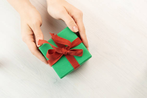 istock christmas gift in recycled packaging in female hands 1427144193