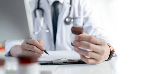 istock Doctor working with laptop computer and writing on paperwork. 1427162958
