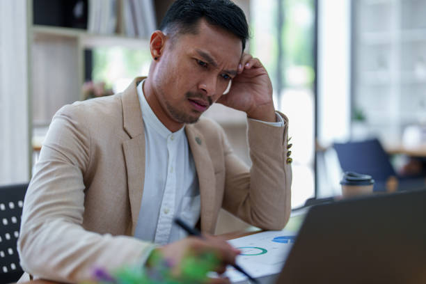 istock Portrait of sme business owner, man using computer and financial statements Anxious expression on expanding the market to increase the ability to invest in business 1427184366