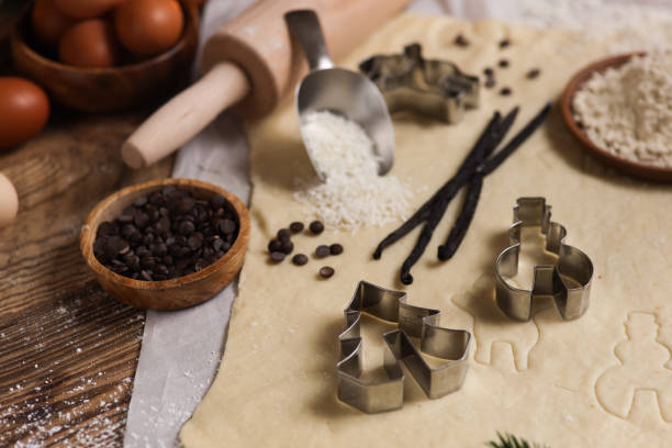 cuocere i biscotti di natale in cucina rustica con tagliabiscotti e pasta - vaniglia spezia foto e immagini stock