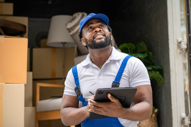 istock Moving service workers outdoors, unloading boxes and checking list is coming to deliver items to the family moving house. 1427196190