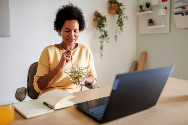istock Mid adult black woman using laptop at home office 1427202076