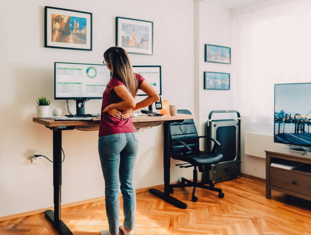 istock Woman with back pain working at standing desk home office 1427202471