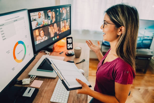 Woman at standing desk home office talking on business video call Woman working from home at standing desk day in the life stock pictures, royalty-free photos & images