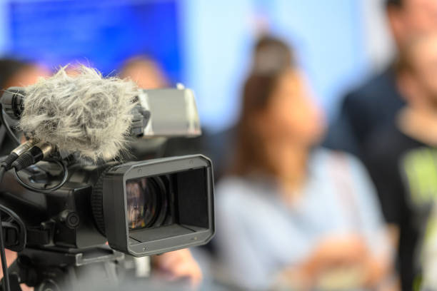 Television cameras on live event Television cameras broadcasting live at the press conference, incidental people in background interview seminar microphone inside of stock pictures, royalty-free photos & images