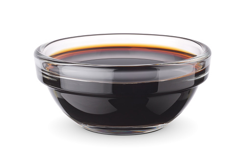 Glass dip bowl with soy sauce isolated on white background. Clipping path included.