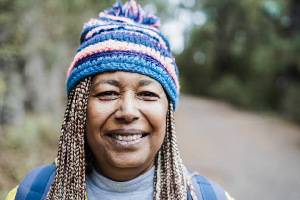 retrato de mulher africana idosa se divertindo durante dia de trekking na floresta montanhosa - foco no rosto - adventure african ethnicity rural scene day - fotografias e filmes do acervo