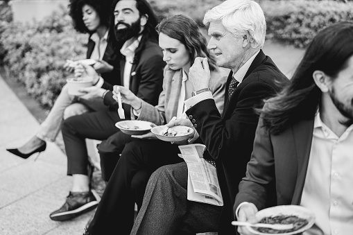 Diverse business people doing lunch break outdoor from office building