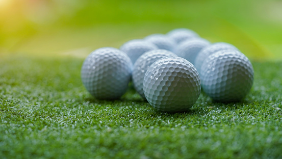 Golf ball on green grass with blur background. Golf balls on green grass in golf course.