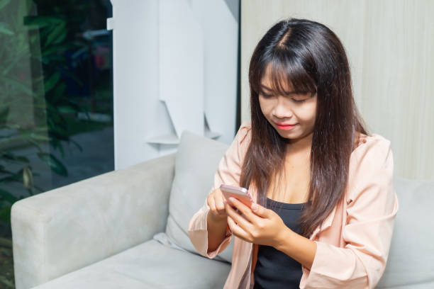 istock close up business woman hands using smartphone tablet typing and touch on white screen for working with app devices vintage style sitting on sofa in lobby office. 1427212165