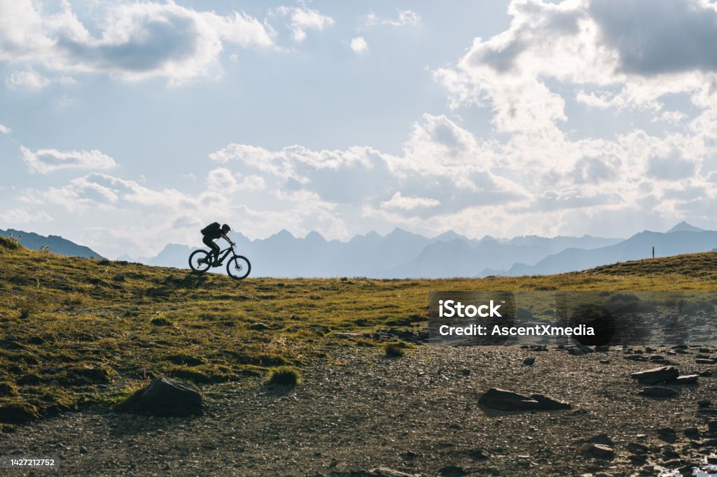 Scenic view of man e-mountain biking in alpine meadow Ticino Canton Cycling Stock Photo