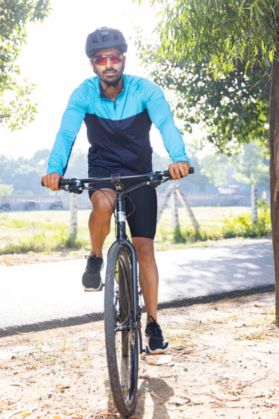 田舎道をサイクリングする若い男性 - cycling senior adult sports helmet men ストックフォトと画像