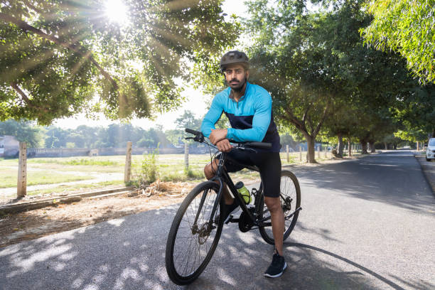 自転車のハンドルバーにもたれかかる思慮深い若者 - cycling senior adult sports helmet men ストックフォトと画像