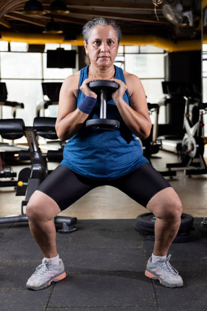 istock Woman lifting weights at the gym 1427220867