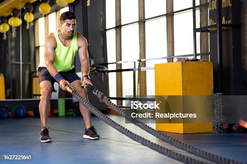 istock Man training with battle rope in gym gym 1427221641