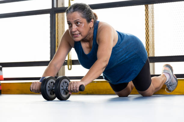 istock Woman strengthening her body by using the abdominal wheel 1427222964