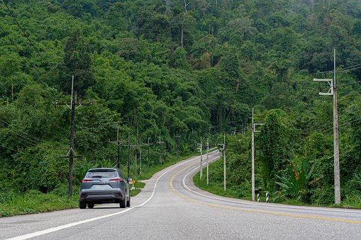 Kanchanaburi Thailand-Sep 23,2022 : Highway traffic in mountains. SUV car parking on Road and mountains view paved road for traveling during vacation