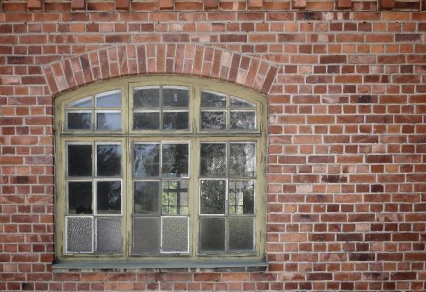 Historic stone house with old wooden window at the top
