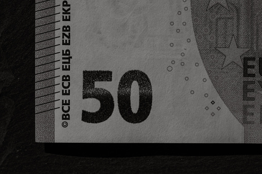 A one hundred dollar bill over a hundred Euro banknote isolated on a white background