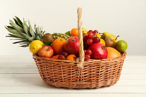 Rustic wooden fruit bowl with pineapple,bananas,apples and oranges