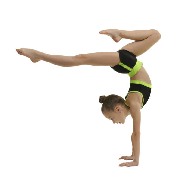 istock Cute little gymnast doing handstand on white background 1427234737