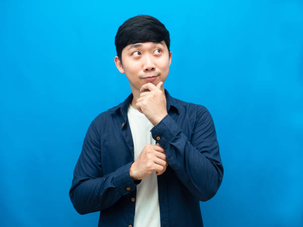 istock Handsome man gesture thinking and looking up portrait blue background 1427235811