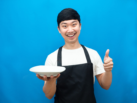 Chef man showing empty dish happiness smile thumb up blue background