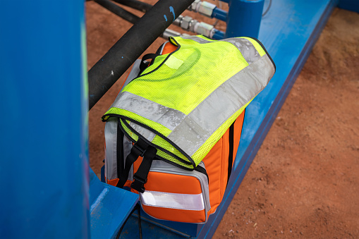 A set of rescue equipment such as signaler reflective vest and first aid kit which is prepared at construction working site, back up for emergency case. Industrial equipment object photo.