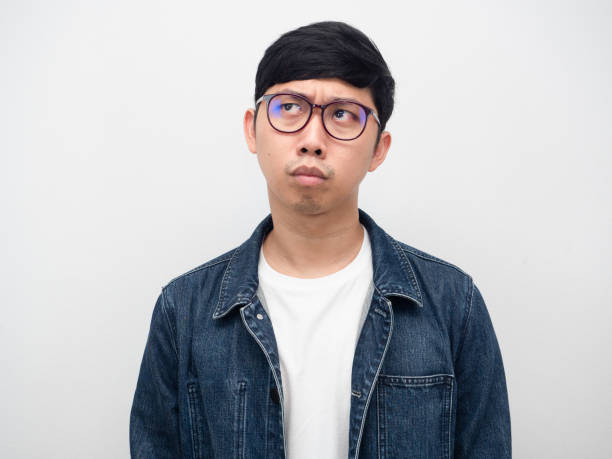istock Young man glasses jeans serious thinking looking up portrait 1427238145