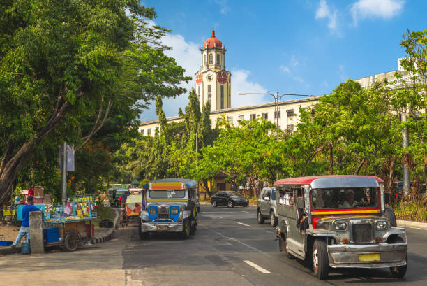 straßenansicht von manila mit jeepney und uhrturm - ermita stock-fotos und bilder