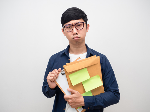 Worker young man glasses holding much work papers feel worried on face portrait