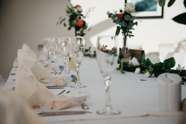 istock Rustic Wedding Reception Top Table seating with glasses, cutlery and dishes 1427241765